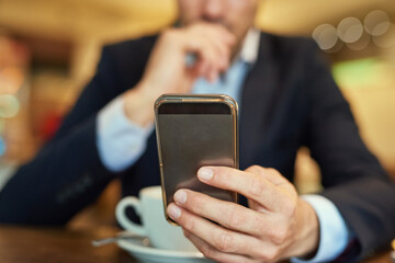 Businessman, smartphone and coffee to relax in cafe for online search, browse internet or reading communication. Male person, cup and mobile technology in shop to scroll, post or update social media
