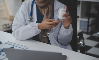 Cropped view of doctor in white coat holding bottle medication, prescribing pills to sick patient...