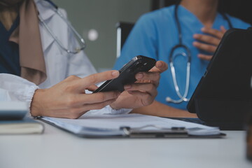 Consultation Online. Unrecognizable doctor using smartphone at workplace, messaging with patient,...
