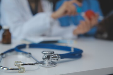 Doctor discussing diagnosis during the meeting. Group of doctor discussing work matter in the office at work. The medical team discusses treatment options with the patient.