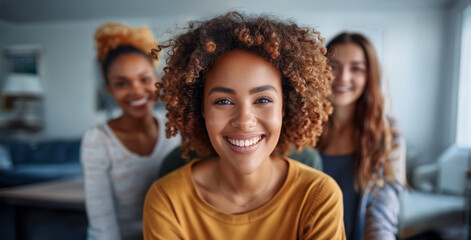 Obraz premium Three women with curly hair are smiling at the camera