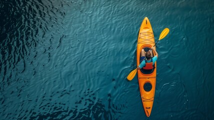 A man kayaking on a lake, against a background of blue water. View from above.