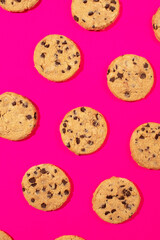 Fresh cookies with chocolate chips on a pink background. Dessert, a pastry shop. Pattern. 