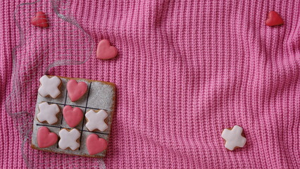 Noughts and crosses. Horizontal Banner for Website. Love Conception. Gingerbread on a Pink Sweater Background. Valentines Day Wallpaper