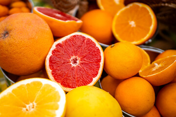 Selection of organic citrus fruits, including oranges, grapefruits, lemons, with some sliced in half to reveal the juicy freshness, offering a refreshing concept of healthy living and natural vitality
