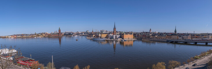 Fototapeta na wymiar Panorama view from the vista point board walk Monteliusvägen, the down town, Town City Hall, the old town Gamla Stan, a sunny spring day in Stockholm