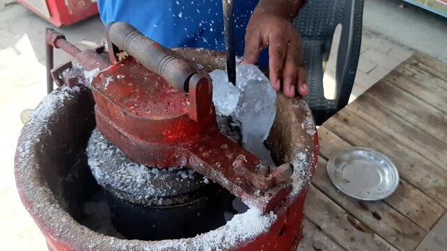Slow Motion Footage A man puts ice on an ice cream machine and breaks it. How to make Qulfa. Manual kulfa making machine in pakistan. The breaking of the ice. Beautiful 4K footage.