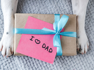 Beautiful gift box, dog paws and note with words of love to Father. View from above. Close-up,...