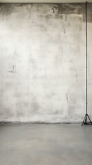 large empty room with concrete wall and tripod