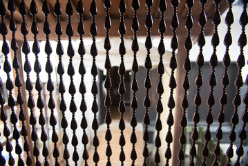 A close up of a curtain with many beads on it