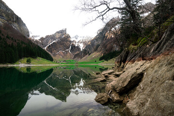 Seealpsee Bergsee im Alpstein in Appenzell in der Schweiz mit Schnee auf den Bergen