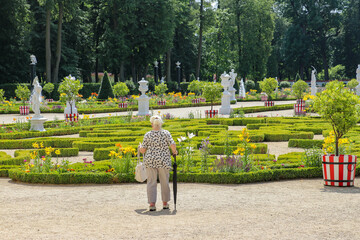 An elderly woman explores the beautiful palace gardens in Białystok, summer 2023, Poland, Podlaskie Voivodeship