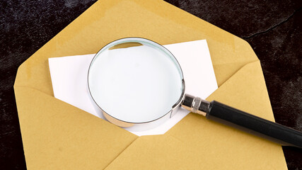 Magnifying glass on top of the secret note with a place to copy on the envelope