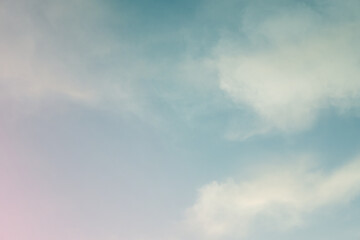 Soft white cloud illuminated by evening light over blue sky background in twilight time. 