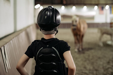 Portrait of a young jockey with a horse, horse riding training, a boy stroking a horse, a lesson...