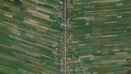 Wide green yellow fields and agricultural village looking down aerial view from above, A long thin...