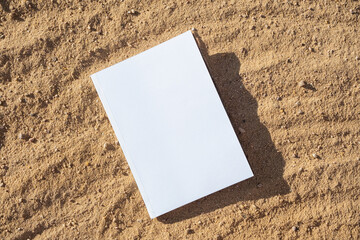 blank book mockup on sandy beach