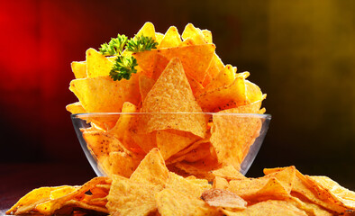 Composition with glass bowl of tortilla chips.