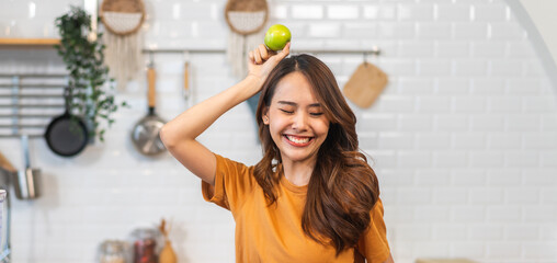 Portrait of beauty body slim healthy asian woman big smile cooking and preparing vegan food healthy holding apple, green apple, dental, teeth, fruit in kitchen at home.Diet.Fitness, healthy food