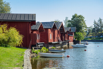 Porvoo, Finland. Townscape of Old town of Porvoo. Picturesque red wooden houses by the river. Green trees, calm water. Warm sunny summer day in nordic country.