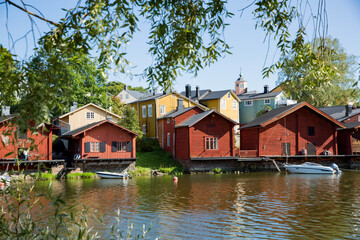 Porvoo, Finland. Townscape of Old town of Porvoo. Picturesque red wooden houses by the river. Green trees, calm water. Warm sunny summer day in nordic country.