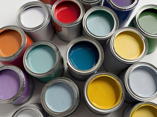 Top view of open paint cans with various colors on a white surface