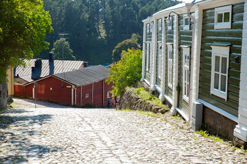 Fototapeta premium Porvoo, Finland. Narrow streets of Old town of Porvoo. Picturesque colorful wooden houses. Historic center, touristic place, landmark of Finland. Warm sunny summer day in nordic country.