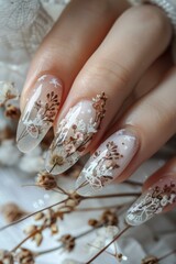 Dried flowers and snowflakes decorate the girl's nails