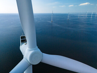 A lone wind turbine gracefully spins in the vast expanse of the ocean, harnessing the power of the...