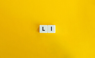 Capital and Small Letter L. Uppercase and Lowercase Letter. Concept of Learning Alphabet. Text on Block Letter Tiles against Yellow Orange Background.