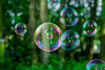 soap bubbles close-up on a background of sun and greenery, abstract background, positive mood, holiday, carelessness