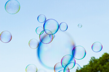 soap bubbles against the sky, reflection of the sun in the bubbles, color play, abstraction