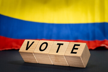 Colombia vote, the word Vote on wooden blocks against the background of the Colombian flag, the concept of voting and taking part in important state and local elections