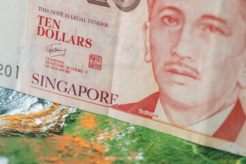 Singapore money, 10 Singapore dollars banknote on the background of the world, financial market concept