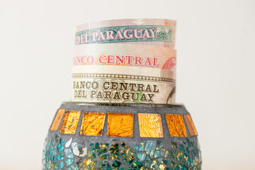 Paraguay money, banknotes sticking out from a decorative bowl, Financial concept, Financial savings of Paraguayans