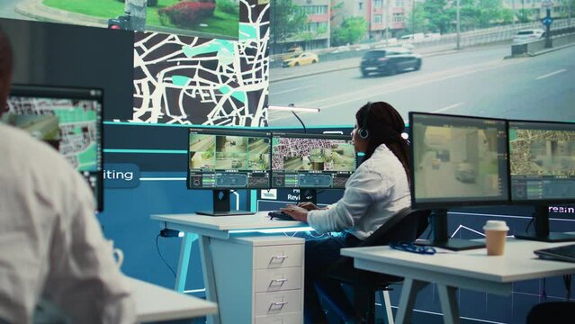 African american employee tracking orders on satellite navigation with gps coordinates, looking for routes to help couriers with express shipping service. Agency worker in control center. Camera B.