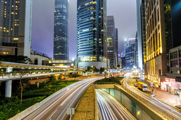 Traffic with streets and skyscrapers at night in city of Hong Kong, China