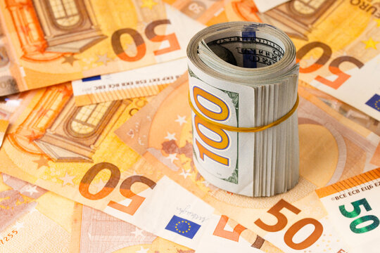 Roll of Hundred us dollar bills  on the euro banknotes . Concept of business strategy.