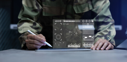 soldier man use stylus pencil to check program of radar and radio aviation for test system of tracking and defense at the dark control room center in monitor station for military technology concept