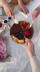 Picnic Delight: Four Unique Cakes Merged as One, Top View with Portions Being Served on a Blanket