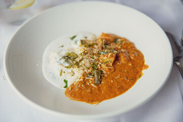 Delicately Plated Indian Cuisine Featuring an Ambiguous Curry Dish with Lamb or Chicken, Accompanied by Basmati Rice and Raita