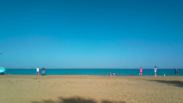 People on Mackenzie Beach in Larnaca, Cyprus filming a airplane landing to Larnaca International Airport.