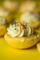 Macro photo of mini lemon pie on yellow background.