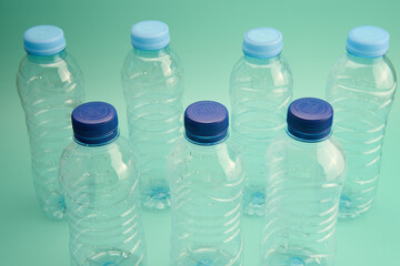 A series of plastic bottles are positioned in a row, emphasizing the need for environmental awareness and responsible waste management.