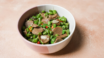 Stir-fried beans in a bowl placed on the table. Top Angle. Close up.