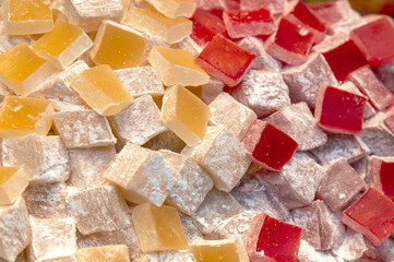 Turkish delight sweet cubes background. Lokum sprinkled with sugar. Top view