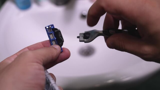 Batumi, Georgia - April 11, 2024.: Packaging with nozzles, cassettes or heads. Gillette is brand of men's safety razors. Man's hand replaces old used cassette with new one.