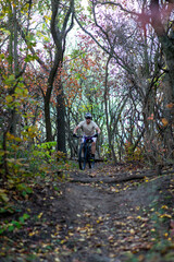 Obraz premium A mountain biker rides a challenging trail through the forest.