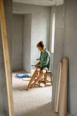 Woman paints walls renovating her apartment