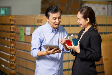 businessman and businesswoman checking basil seed drink or product in the beverage factory